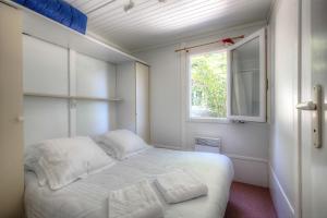 萨尔拉拉卡内达Les Chalets du Périgord的一间小卧室,配有白色的床和窗户