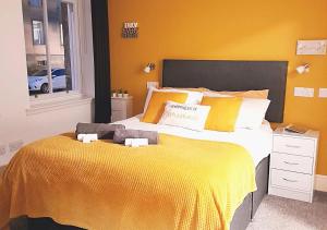 柯科迪Double Ensuite Bedroom near Edinburgh的一间卧室配有一张带黄色毯子的大床