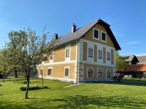 SittersdorfTemelhof - Landhaus mit Sauna und Kamin的院子中一棵树的大型砖房