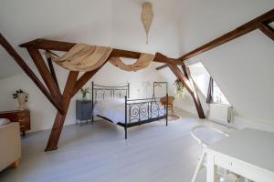 聚特芬De Hilde的卧室配有一张床铺,位于带木梁的房间