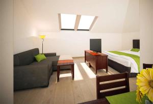 LanzenkirchenMattone Aparthotel的客厅配有沙发和1张床