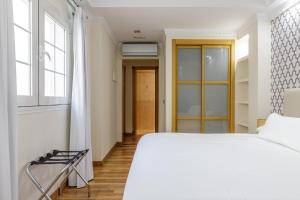马拉加H-A Hotel Trebol的卧室配有白色的床和窗户。