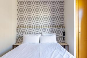 马拉加H-A Hotel Trebol的卧室内的一张带两个白色枕头的床