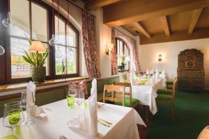 萨尔茨堡嘎斯霍夫布朗德斯塔特酒店的餐厅设有白色的桌椅和窗户。