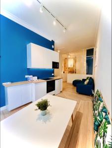蒙彼利埃Suite Bayle - Standing - Hyper centre的厨房配有白色桌子和蓝色的墙壁