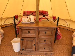 特鲁罗Cox Hill Glamping Benson的帐篷内的木制梳妆台和2个卫生间