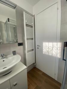 马尼亚戈La corte di Bacco的白色的浴室设有水槽和镜子