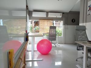 Ban Mo NaeCOWORX Koh Lanta的一间房间,地板上设有一张桌子和一个粉红色的球