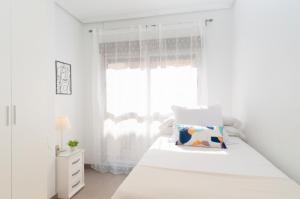 瓜尔达马尔·德尔·塞古拉Apartamentos Turisticos Rent Guardamar的白色的卧室设有床和窗户