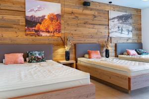 卡普伦Mountain Hotel Luis的木墙客房的两张床