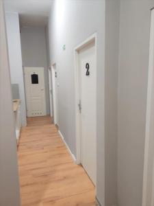 波兹南Rynek 7的走廊设有白色墙壁和木地板