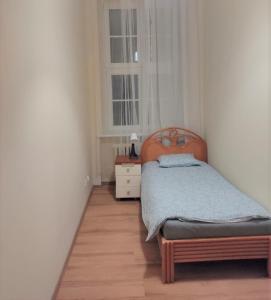 波兹南Rynek 7的一间小卧室,配有床和窗户