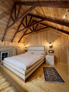 伊斯梅尔雷Lakeside Garden - Ismayilli Guest house的木墙客房内的一张大床