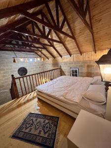 伊斯梅尔雷Lakeside Garden - Ismayilli Guest house的一张位于带木制天花板的客房内的大床