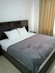 阿克拉Nuben Court-Accra的卧室配有带白色枕头的大床