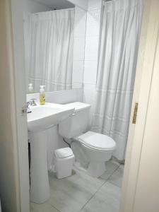 拉塞雷纳Casa Hostal Paso por La Serena的白色的浴室设有卫生间和水槽。