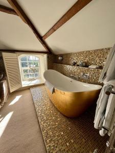 圣大卫Crug Glas Country House的带窗户的浴室设有大浴缸