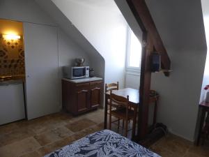 图尔Studio calme au coeur de Tours的客房设有一张床和一张带微波炉的桌子。