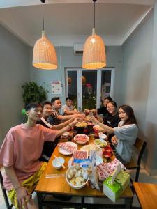 下龙湾VietHouse Homestay Ha Long的一群坐在桌子旁吃食物的人