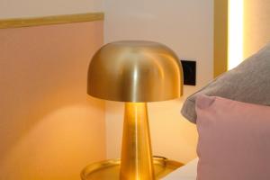 巴黎卡洛琳公主酒店的坐在床边桌子上的金灯