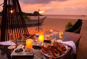 贝鲁沃勒Ceylon Serenity Villa的海滩上一张桌子,上面放着盘子和蜡烛