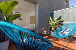 巴塞罗那巴塞罗那时尚客房酒店的阳台配有2把蓝色椅子和浴缸