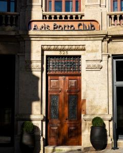 波尔图Axis Porto Club Aliados的一座带木门的建筑,上面有标志