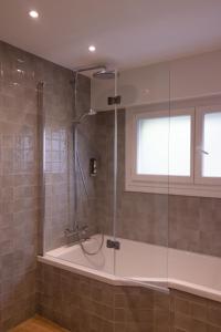 瓦讷Logis Golfe Hotel的带淋浴的浴室和玻璃门