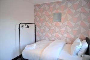 伦敦London Zone 2, 2 Bedroom House的卧室配有白色的床和几何墙