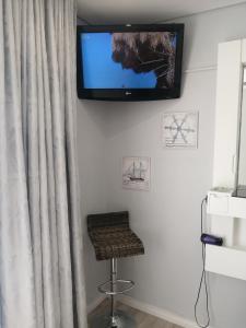 莫塞尔湾Ocean room @ 66 Fynbos的挂在墙上的电视,带凳子和凳子
