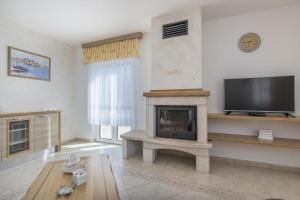 卡里高多Villa Mateja的客厅设有壁炉和平面电视。