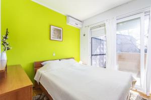 卡里高多Apartment Carigo的绿色卧室设有床和窗户