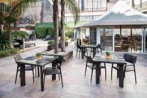 巴塞罗那安琪儿加泰罗尼亚酒店的一间带桌椅和凉亭的餐厅