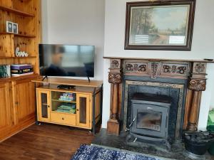 米尔敦马尔贝Skye's Atlantic Retreat的客厅设有壁炉和电视。