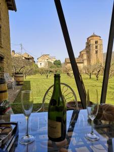 圣克鲁斯德拉塞罗斯Casa Rural Barangua en el Pirineo Aragonés的一张桌子上放着一瓶葡萄酒,放上两杯