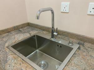 阿布贾C7 Hazelwood Residence & Suites的厨房水槽和柜台上的水龙头