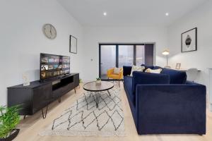 泰晤士河畔金斯顿SERCASA - Appletree Court - Kingston的客厅配有蓝色的沙发和桌子