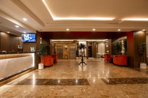 艾卜哈Aman Hotel Suites的大堂,设有红色椅子和电视