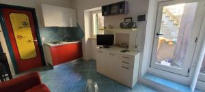 Isola del Gigliocasa arcobaleno的一个带红色门和电视的小厨房