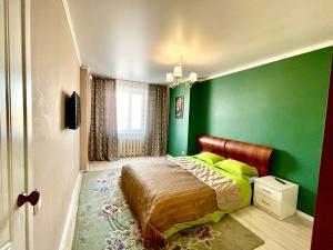 巴甫洛达尔4х комнатные апартаменты的一间带绿色墙壁和床的卧室