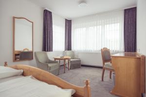 厄斯特里希-温克尔Hotel Schwan的酒店客房带一张床、一张桌子和椅子
