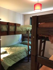 萨尔塔Lapacho Hostel Salta Coliving的带三张双层床和一盏灯的房间