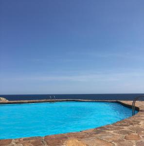 巴古尔Apartamento con playa y vistas en la Costa Brava的蓝色的游泳池,背景是大海
