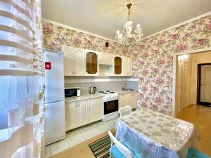 巴甫洛达尔1 комнатные апартаменты的厨房配有桌子和白色冰箱。