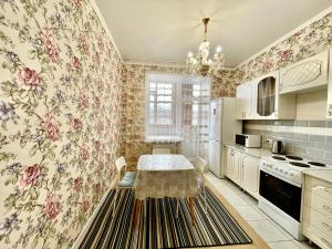 巴甫洛达尔1 комнатные апартаменты的厨房配有桌子,厨房配有花卉壁纸