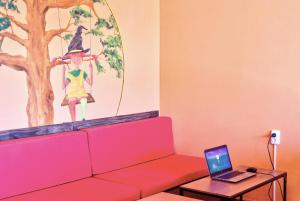 圣地亚哥－德孔波斯特拉Meiga Backpackers Hostel的一间配有沙发和一张桌子上的笔记本电脑的房间