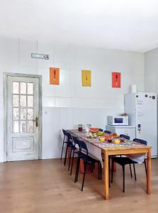 圣地亚哥－德孔波斯特拉Meiga Backpackers Hostel的厨房配有桌椅和冰箱。