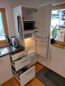 施伦斯Haus Ströhle的厨房配有带微波炉的开放式冰箱