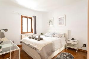 巴塞罗那Barcelona Beach Home的白色的卧室设有床和窗户