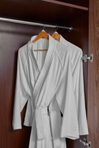 麦加voco Makkah an IHG Hotel的挂在架子上的一组白色衬衫